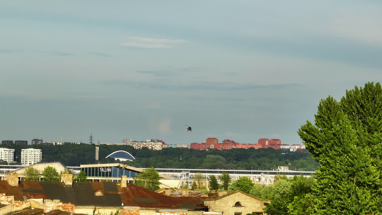 Telephoto drone shot of a helicopter flying over Tallinn city, summer in Estonia