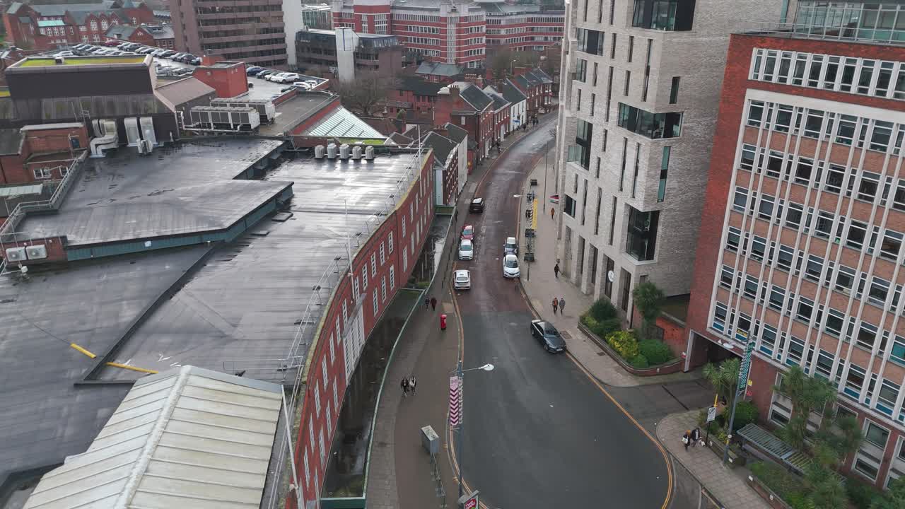 A street view of Norwich, Norfolk, showcasing turrets, churches, shops, and modern buildings