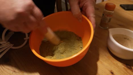 mezcla de polvo de moringa y jengibre para hacer un suplemento de hierbas medicinales en un tazón naranja