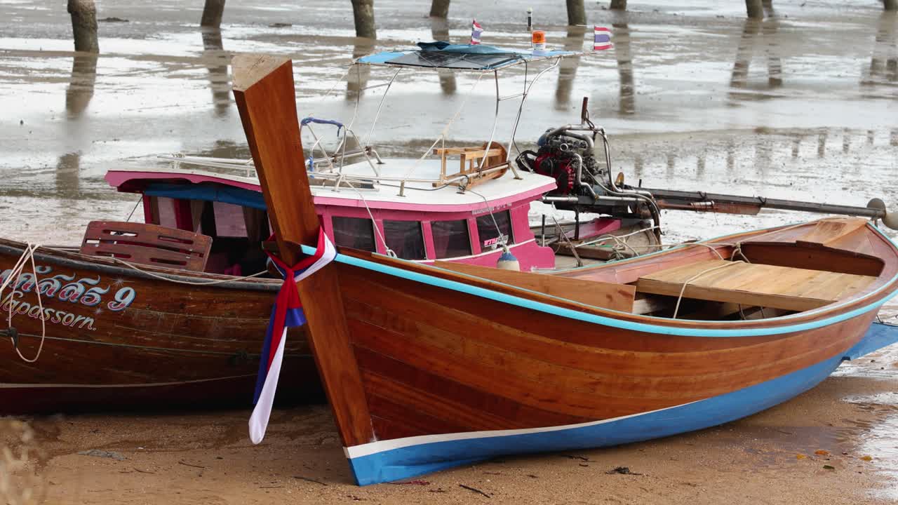 los barcos de cola larga de madera con colores vibrantes atracados en un muelle de phuket. la iluminación nublada crea una atmósfera serena y tranquila