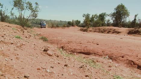 A-van-crowded-with-travelers-makes-its-way-along-a-dirt-road-in-Africa