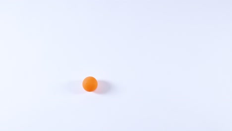 orange ball rolling across a white surface