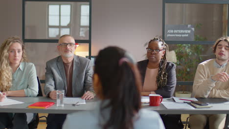 recruitment committee interviewing female candidate in office
