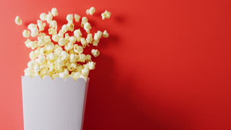 video of close up of popcorn on red background