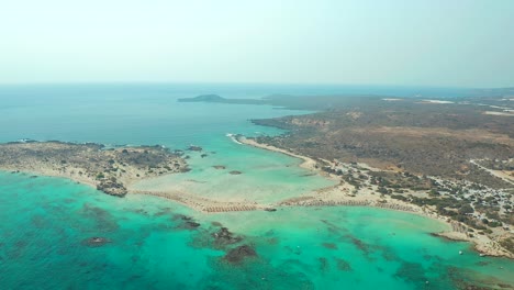 aerial view flying towards sandbanks and turquoise water at elefonissi beach, approach motion