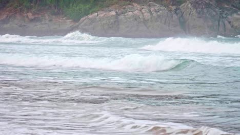 Ocean-waves-breaking-into-the-shore-on-the-beach-in-Phuket,-Thailand