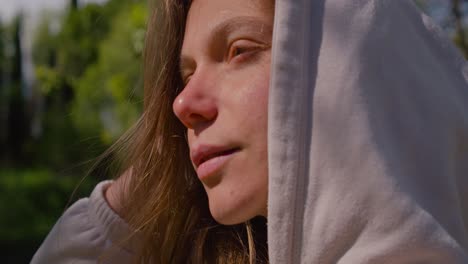 Face-shot-of-beautiful-woman-with-long-brown-hair-and-hoodie-in-natural-enviroment