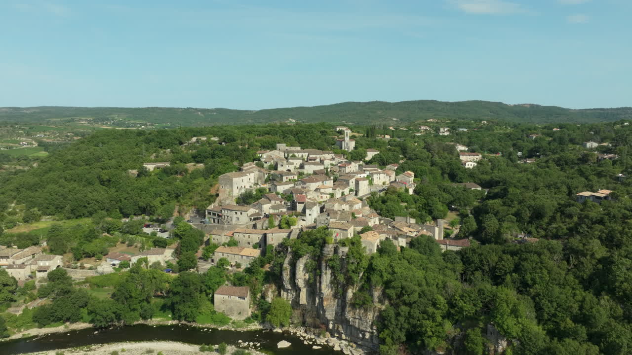 Aerial flying towards Balazuc village, passing over Ardeche river, France