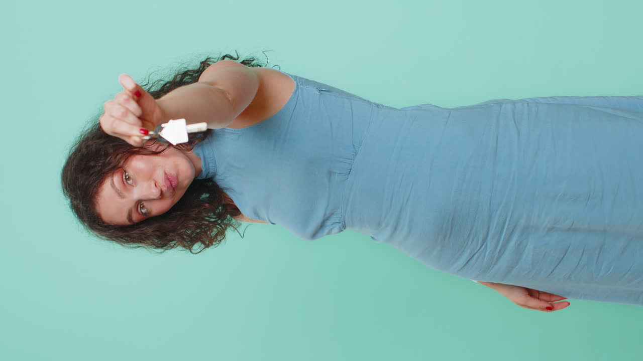 Woman real estate agent showing the keys of new home house apartment buying or renting property