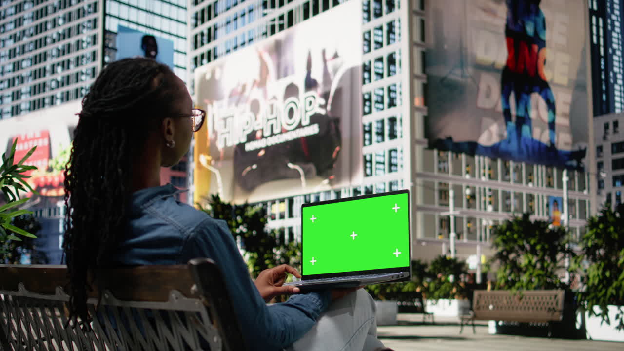 Mockup isolato su laptop tenuto da una donna afroamericana che si rilassa su una panchina.