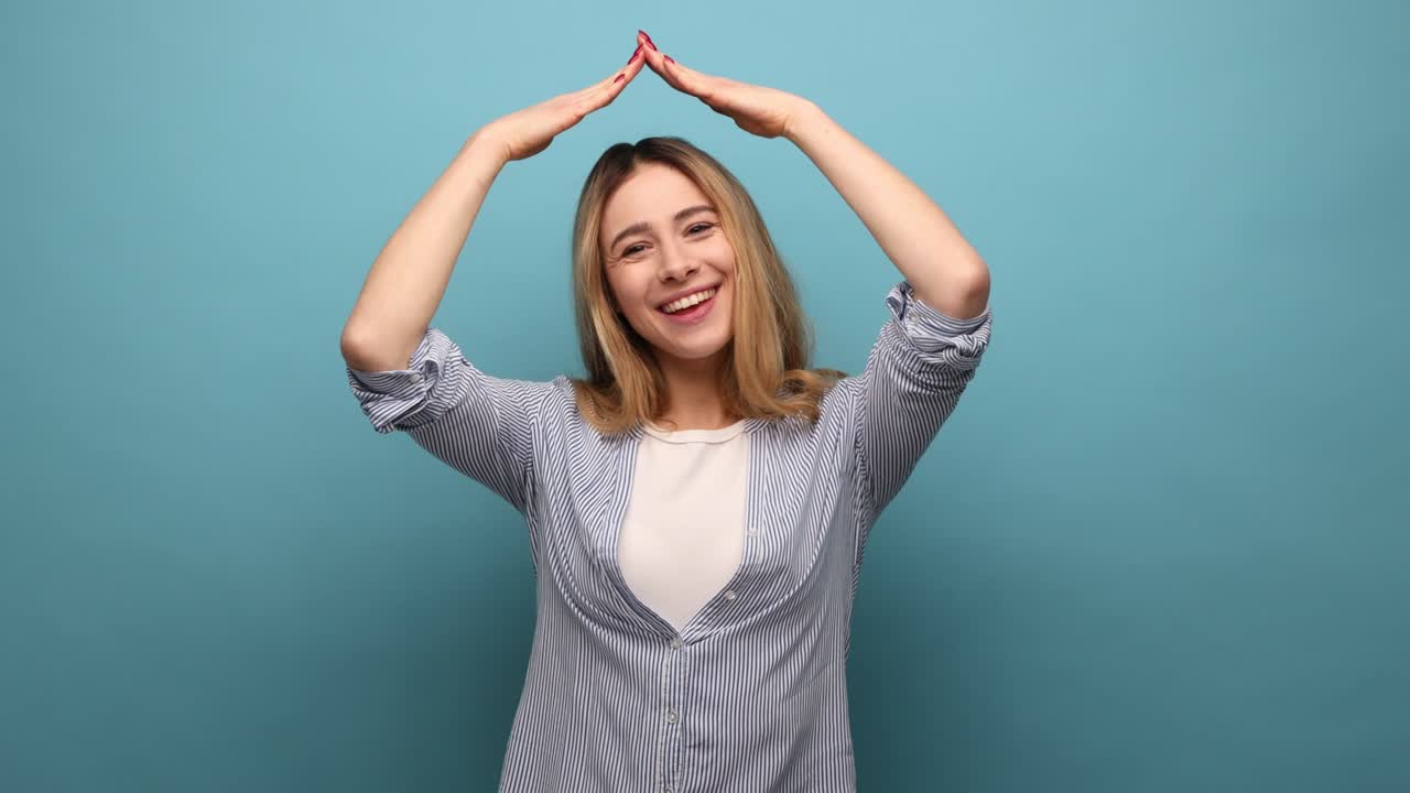 mujer con cabello ondulado haciendo el gesto del techo de la casa y sonriendo, concepto de seguro de vida, protección.