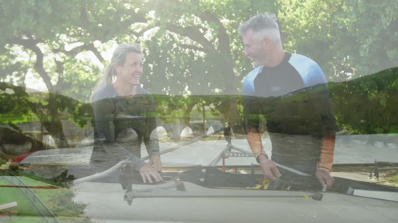 Preparing rowing equipment, two people with scenic river landscape animation overlay