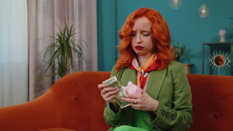 pobre chica pelirroja con una alcancía y un billete de un dólar, crisis financiera, bancarrota, pobreza
