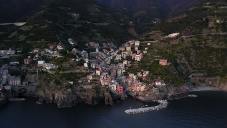 arco aéreo de casas coloridas de riomaggiore en la ladera de una colina, italia