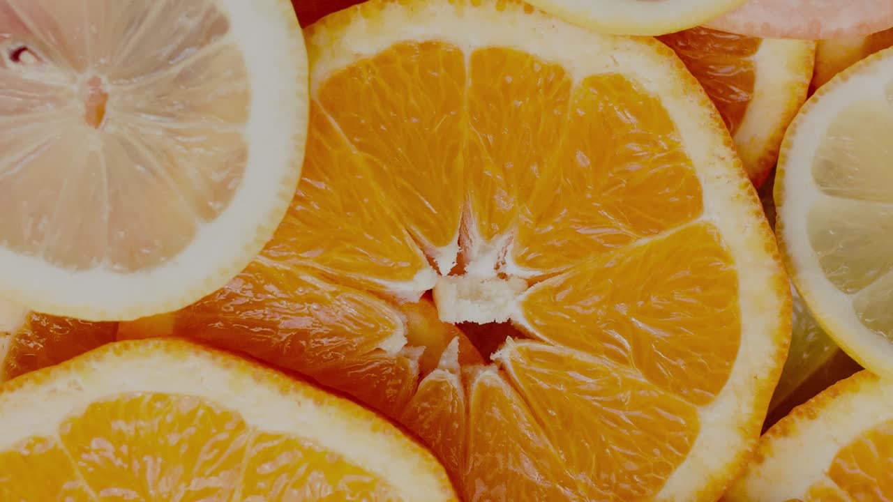 Una vista ravvicinata e colorata di agrumi affettati, con spicchi arancione brillante e giallo pallido di arance e limoni freschi. Le fette sono disposte per enfatizzare le loro texture naturali.