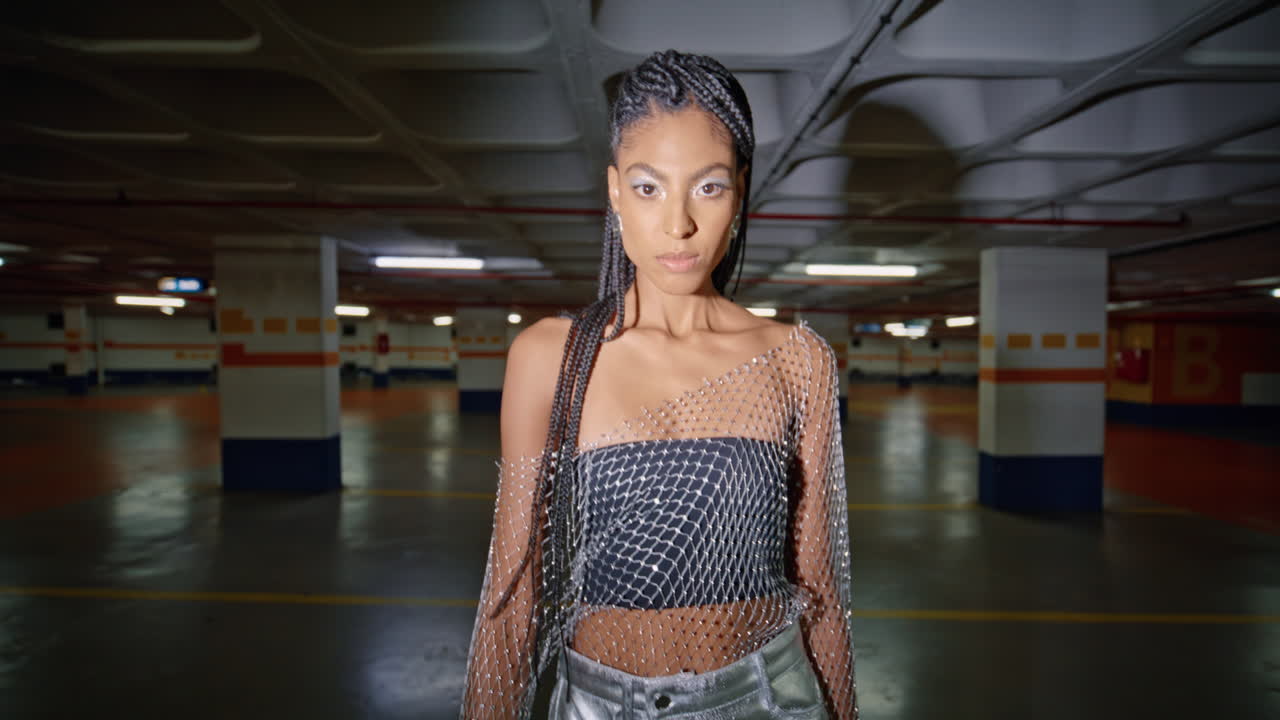 retrato de una mujer sexy posando en un estacionamiento subterráneo oscuro.