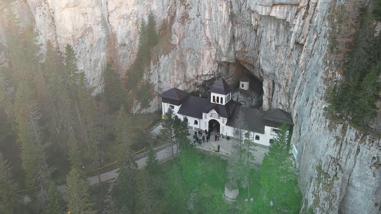 Aerial drone view of The Ialomitei Cave in Romania. Entrance into the cave with tourists in Bucegi Mountains