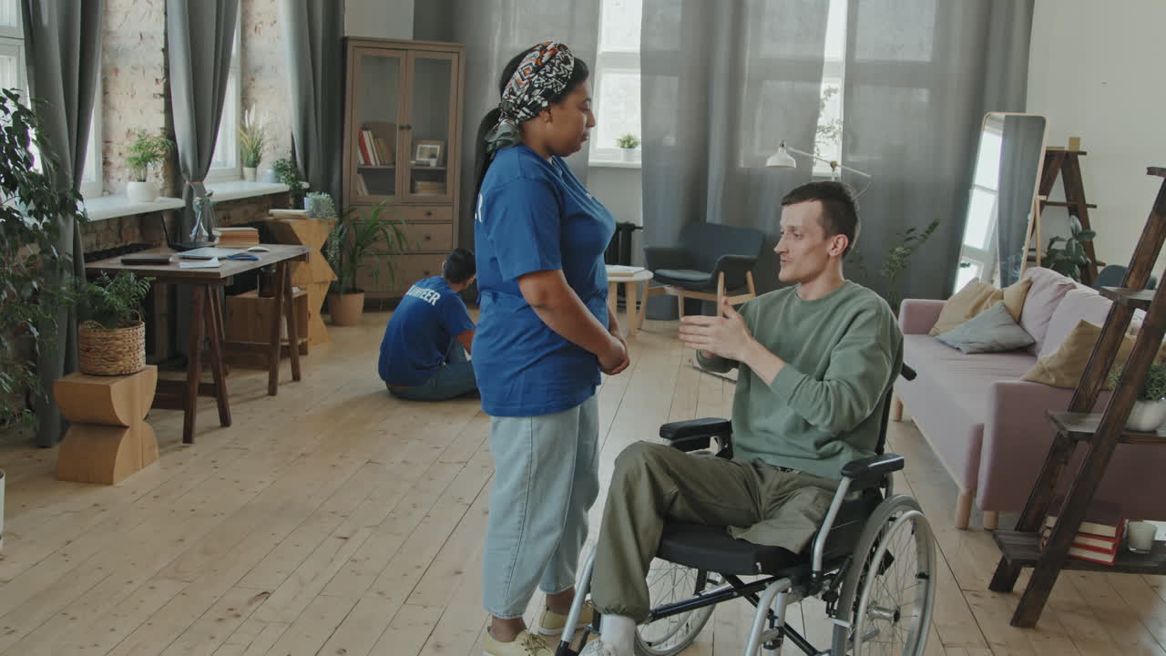 Man in Wheelchair and Female Volunteer Hugging