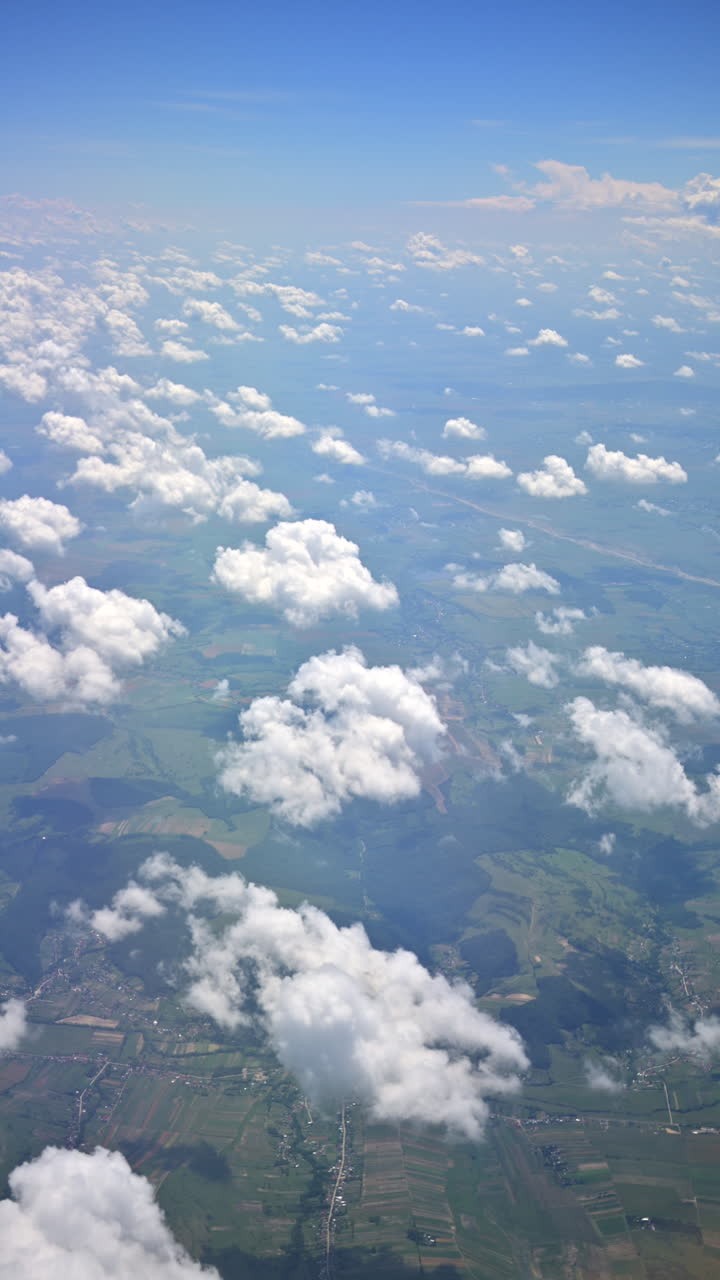 View of the clouds from an airplane window. Vertical
