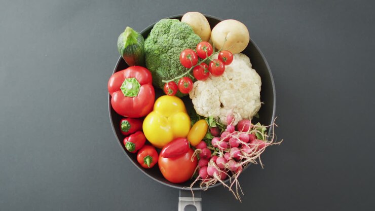 Video of fresh vegetables in pan over grey background