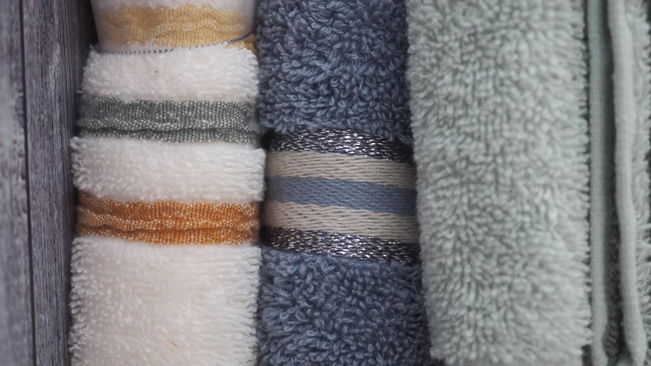 Rolled towels of different colors and textures