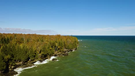 Revelación-Aérea-Hacia-Atrás:-Las-Olas-Chocan-En-La-Costa-Rocosa-Del-Lago-Michigan,-El-Parque-Del-Condado-De-Cave-Point-En-Otoño