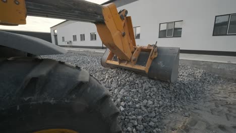 tractor moves rubble to truck. excavator-loader rakes rubble from pile at construction site and loads dump truck. clearing site