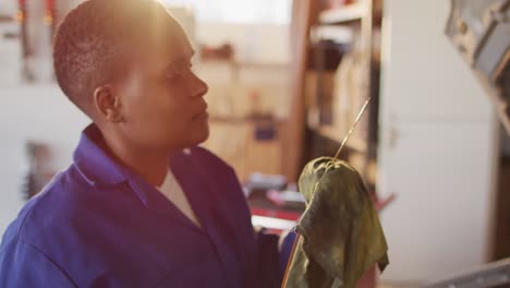 video de una mecánica de automóviles afroamericana comprobando el nivel de aceite