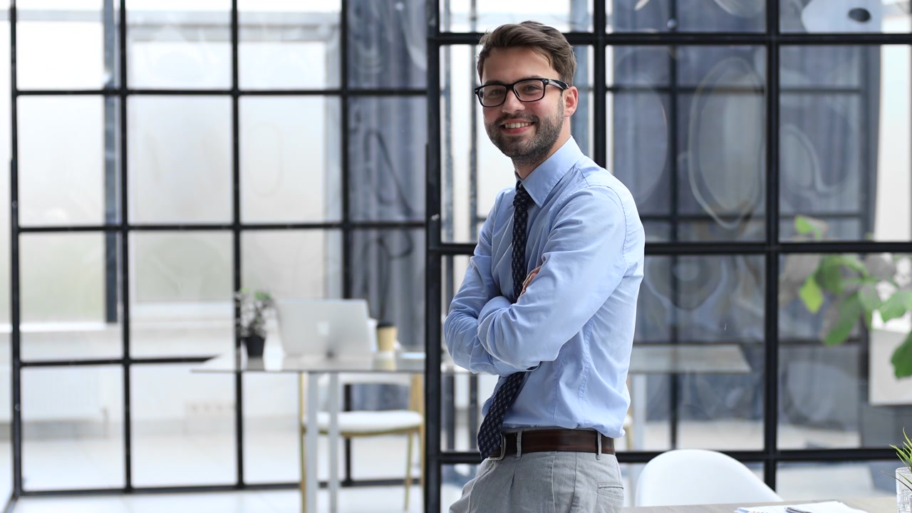 Giovane professionista sorridente a braccia incrociate in ufficio