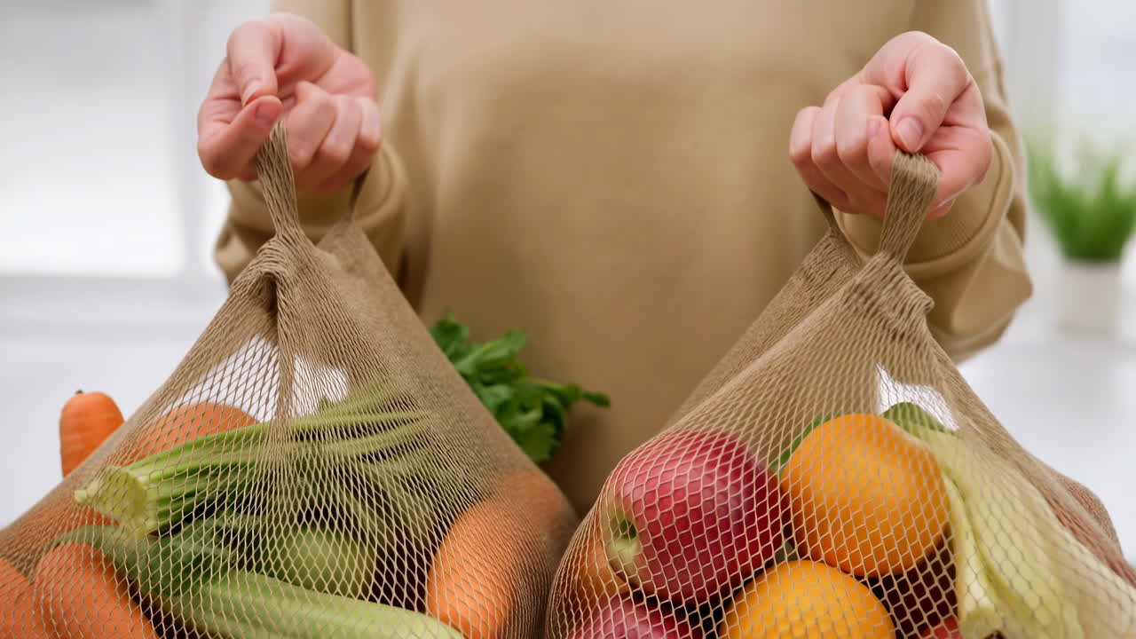 Mãos Segurando Sacos de Malha Reutilizáveis Cheios de Frutas e Vegetais Frescos