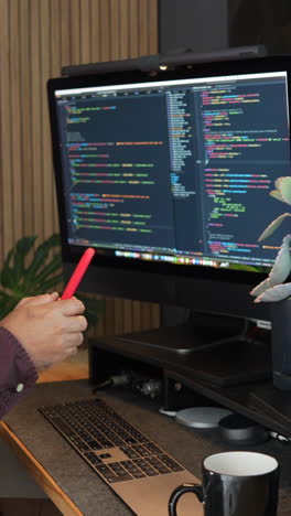 vertical video showcasing a close-up shot of an it support specialist engaging with code on a dual-screen setup. warm lighting, modern office ambiance. ideal for tech and mobile content
