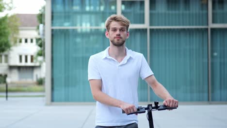 un joven empresario camina por delante de un edificio moderno en un scooter eléctrico