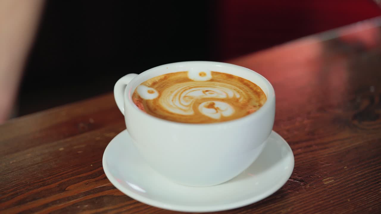 Barista makes a drawing on coffee. Art of making cappuccino in a cup.