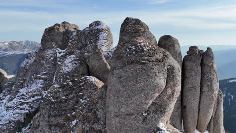 las escarpadas cimas de las montañas ciucas bajo un cielo azul claro, manchas de nieve aferradas a las rocas