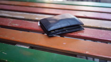 black leather wallet on a colorful wooden table