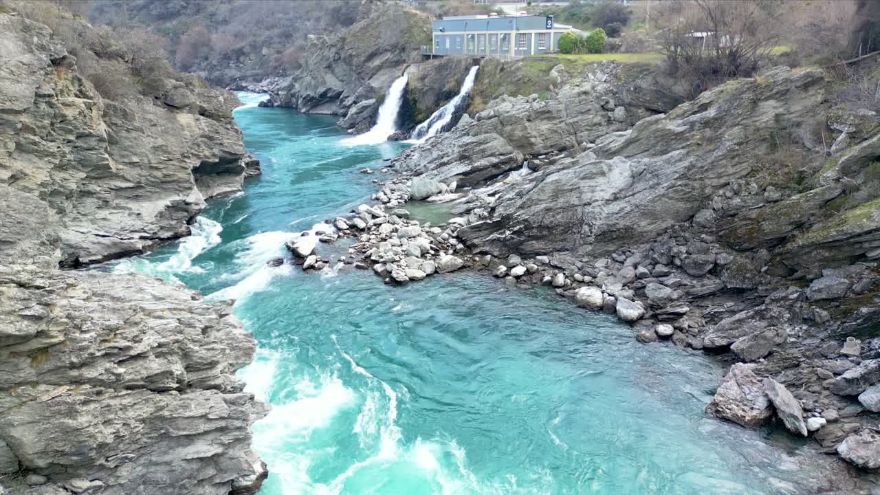 Drone footage tilting up from the river to the Roaring Meg hydro scheme on the South Island of New Zealand