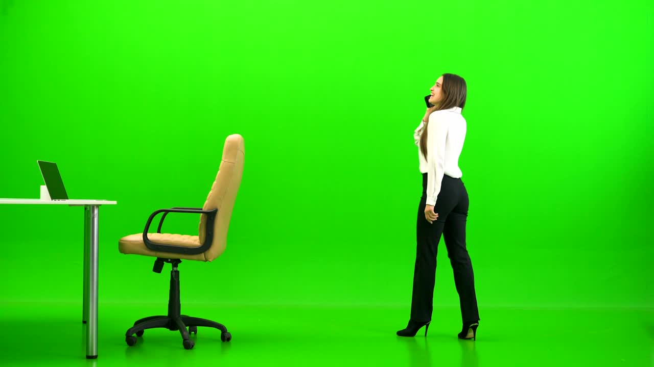 비즈니스 우먼이 초록색 배경의 테이블에서 휴식을 취하고 있습니다.