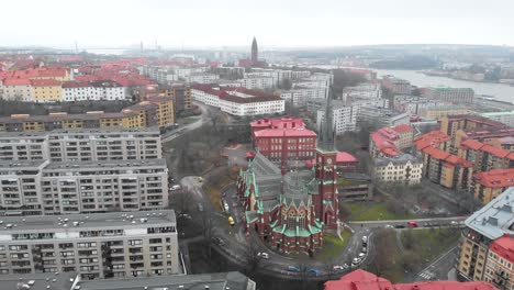 impresionante vuelo aéreo hacia la iglesia oscar fredrik rodeada de horizonte y edificios en un día nublado de invierno en la ciudad de gotemburgo, suecia