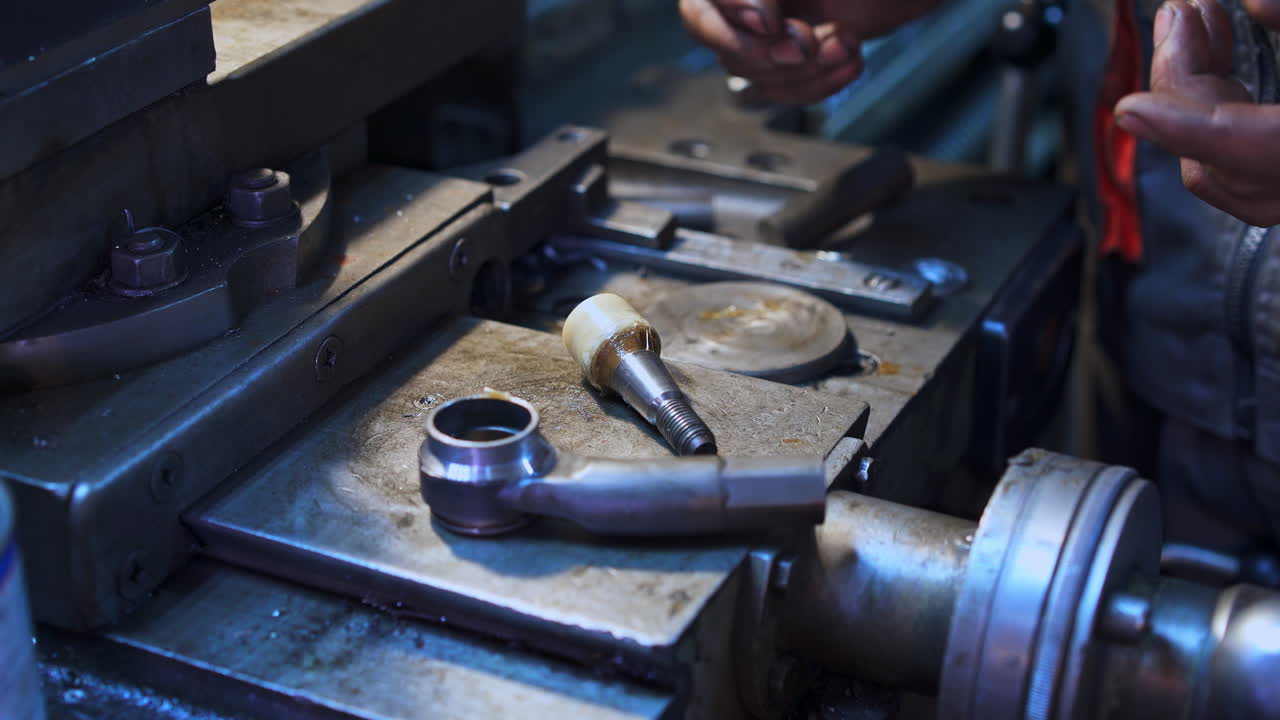 Hands of turner taking two details and sticking them together. Turner making details in his workshop. Turning lathe backdrop.