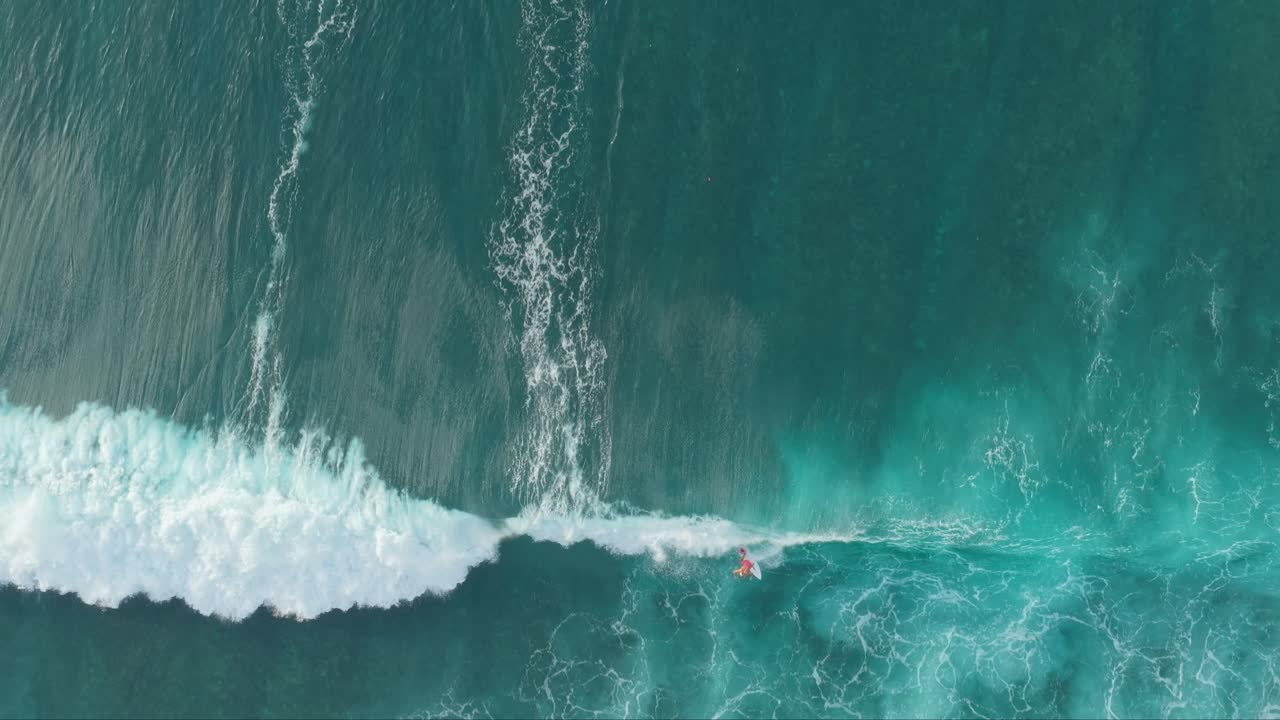Aerial top down view of surfers catching ocean waves