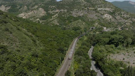 slow motion of train moving on the railway towards tunnel in the mountain