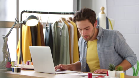 male student or business owner working in fashion using laptop in studio