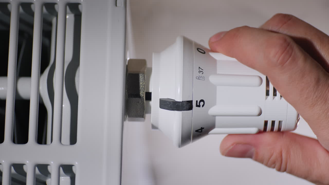 el hombre establece la temperatura del radiador en el concepto de ahorro de energía de la habitación