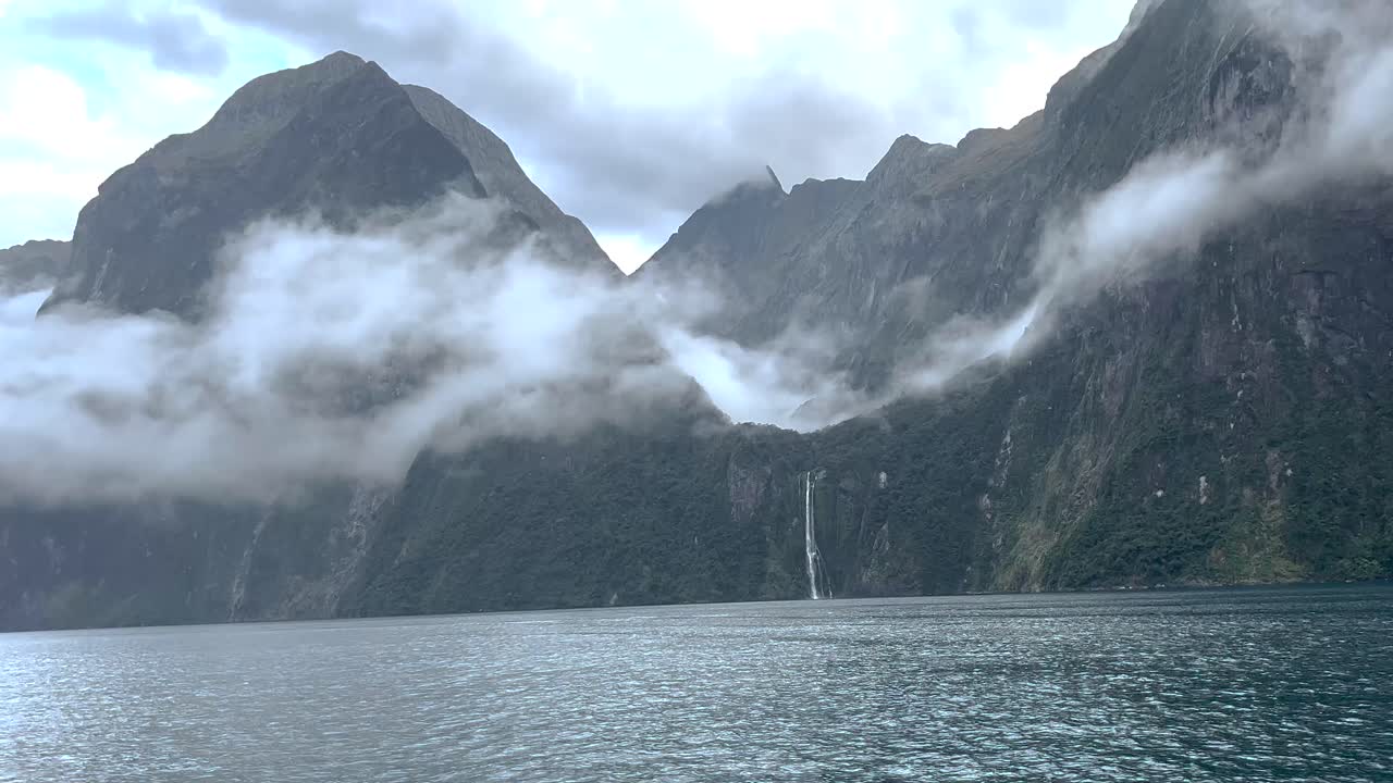 Vesiputous ja dramaattiset vuoret Milford Sound -vuonossa, Uuden-Seelannin matkakohde