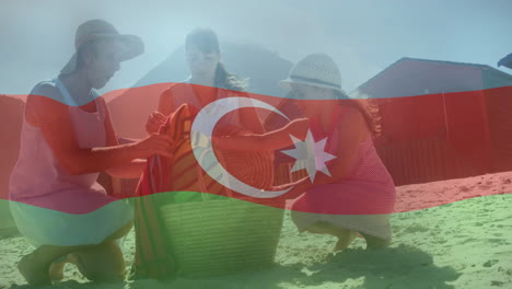 packing basket on beach, women with azerbaijan flag overlay, preparing picnic