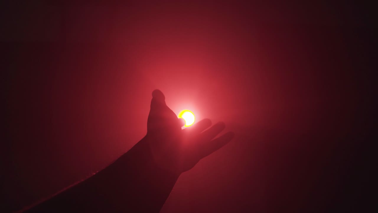A silhouette hand against red strobe light. Looking for freedom, offering help concept  - static studio shot