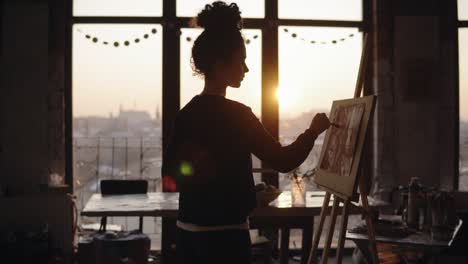 Artista-Femenina-Trabajando-En-Un-Estudio-De-Arte-De-Estilo-Loft-Minimalista,-Terminando-Su-Trabajo,-Agregando-Pequeños-Detalles-A-La-Pintura