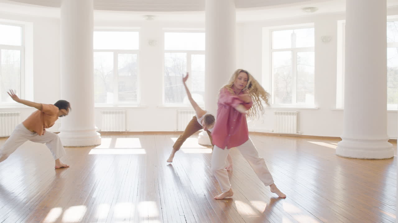 다민족 현대 무용수 그룹이 스튜디오를 돌아다니며 춤을 춥니다.