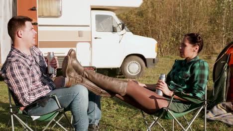 Caucasian-copuple-relaxing-together-on-camping-chairs