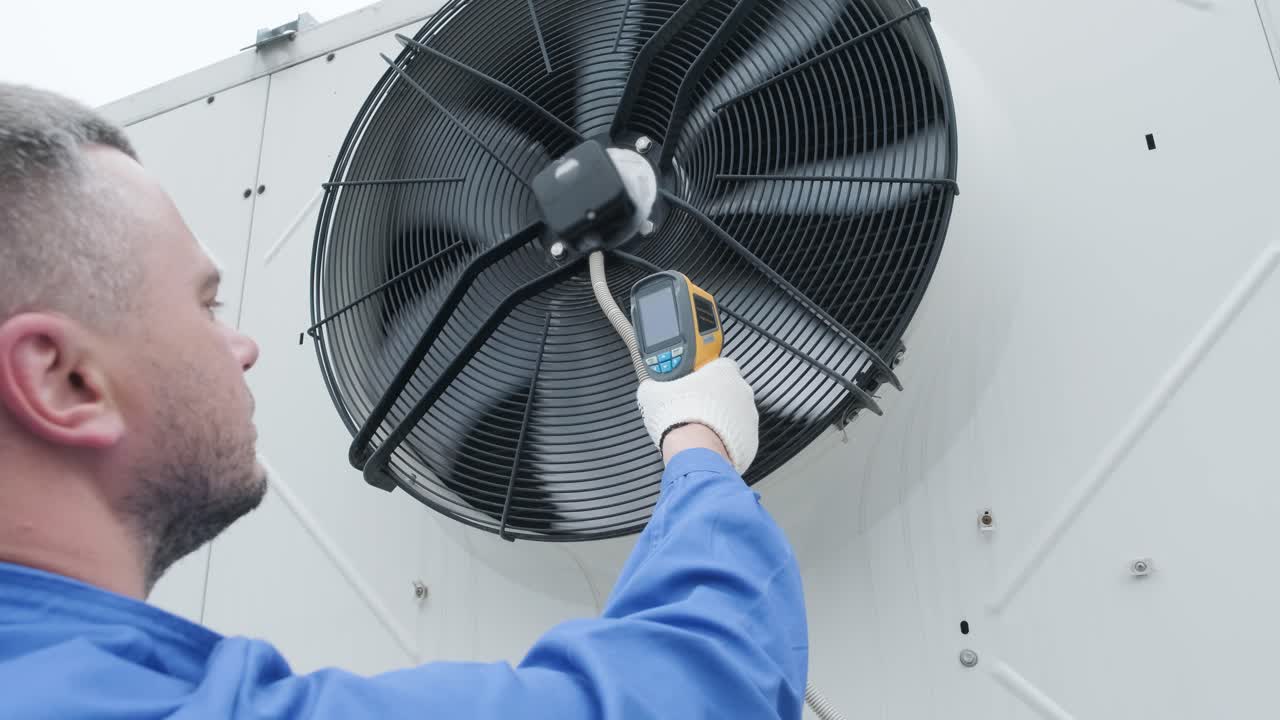El técnico utiliza un termómetro infrarrojo de imágenes térmicas para comprobar el intercambiador de calor de la unidad de condensación